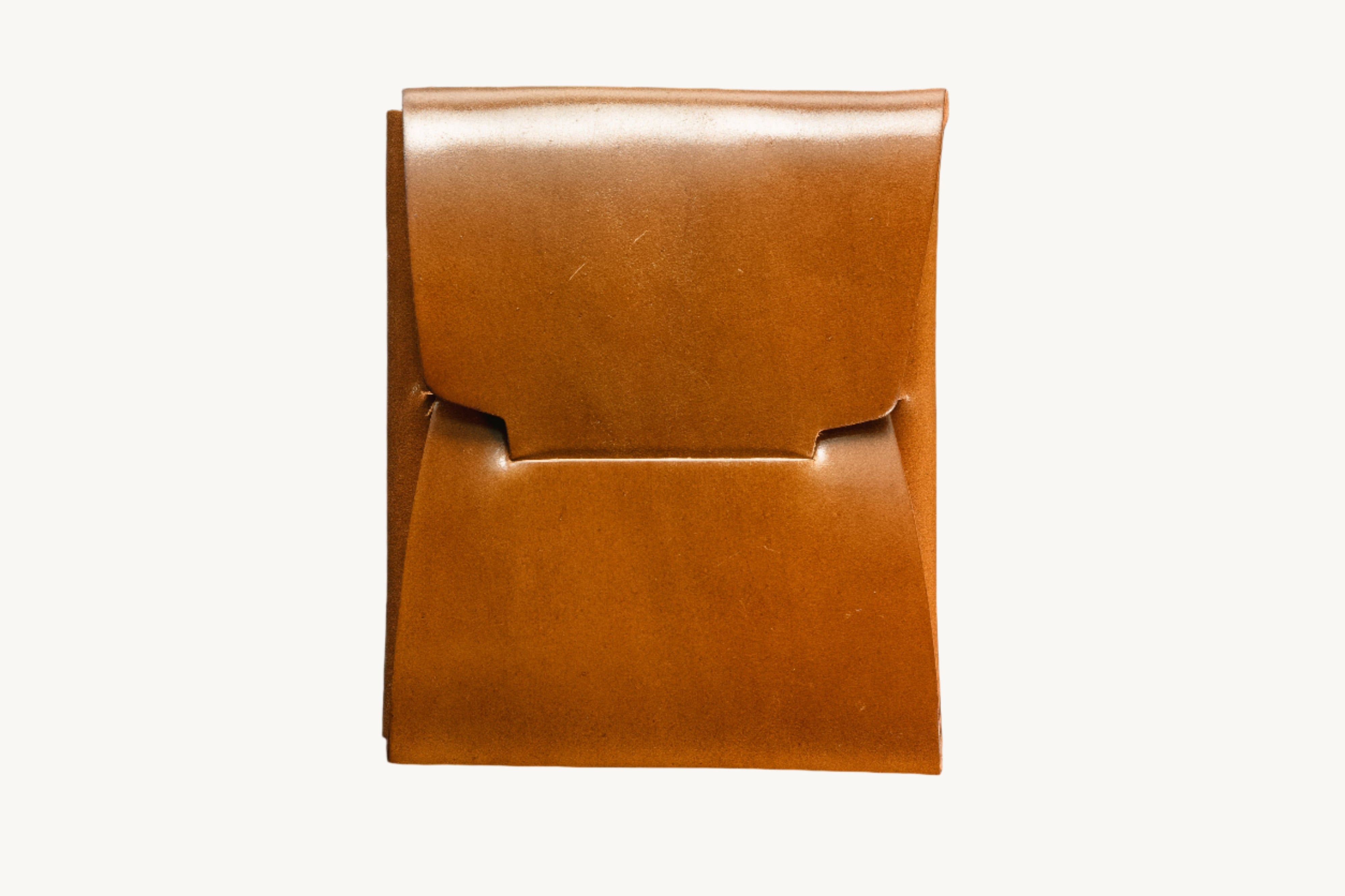 A brown Horween bourbon shell Cordovan leather wallet on a dark textured surface.