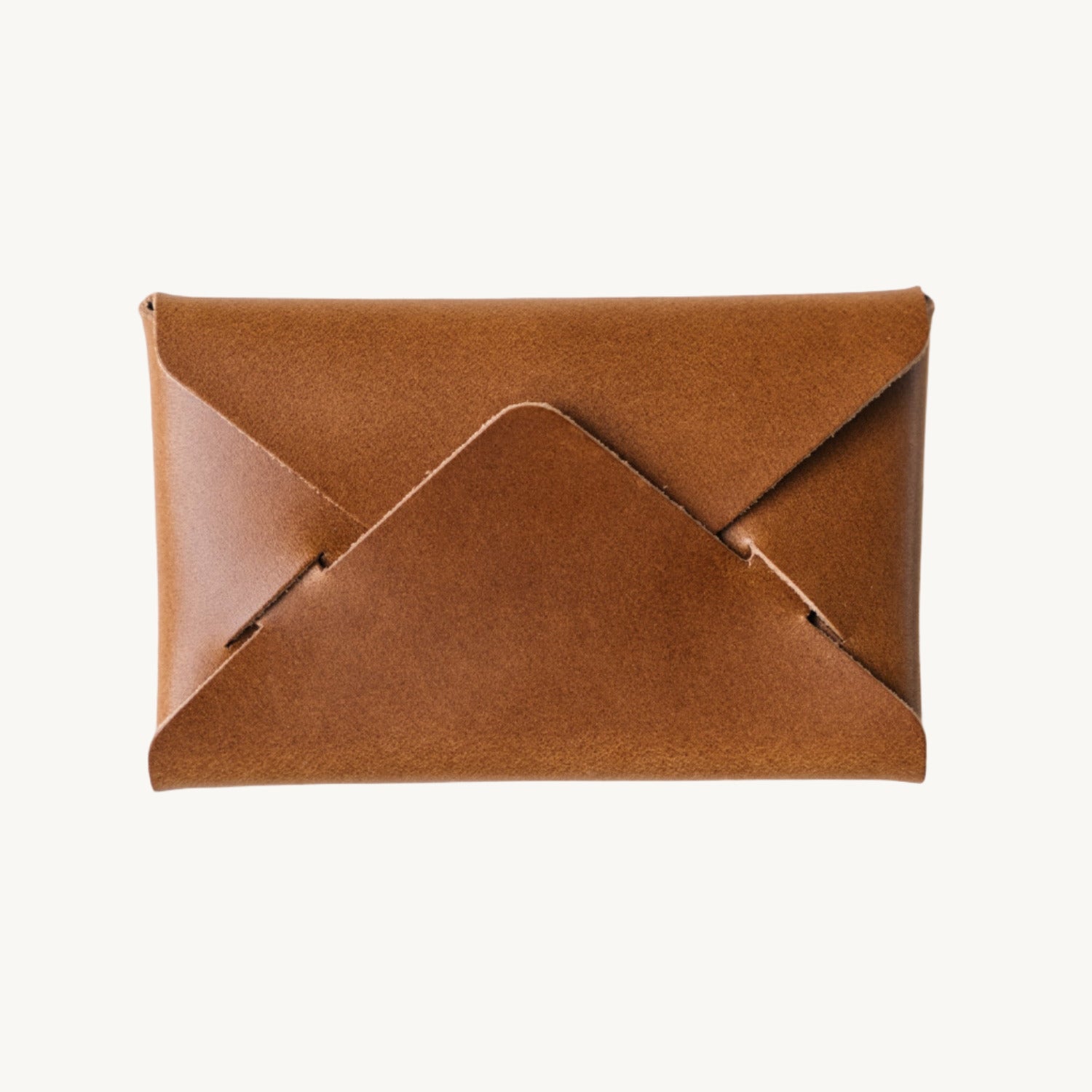 A brown leather envelope wallet laid flat against a neutral background.