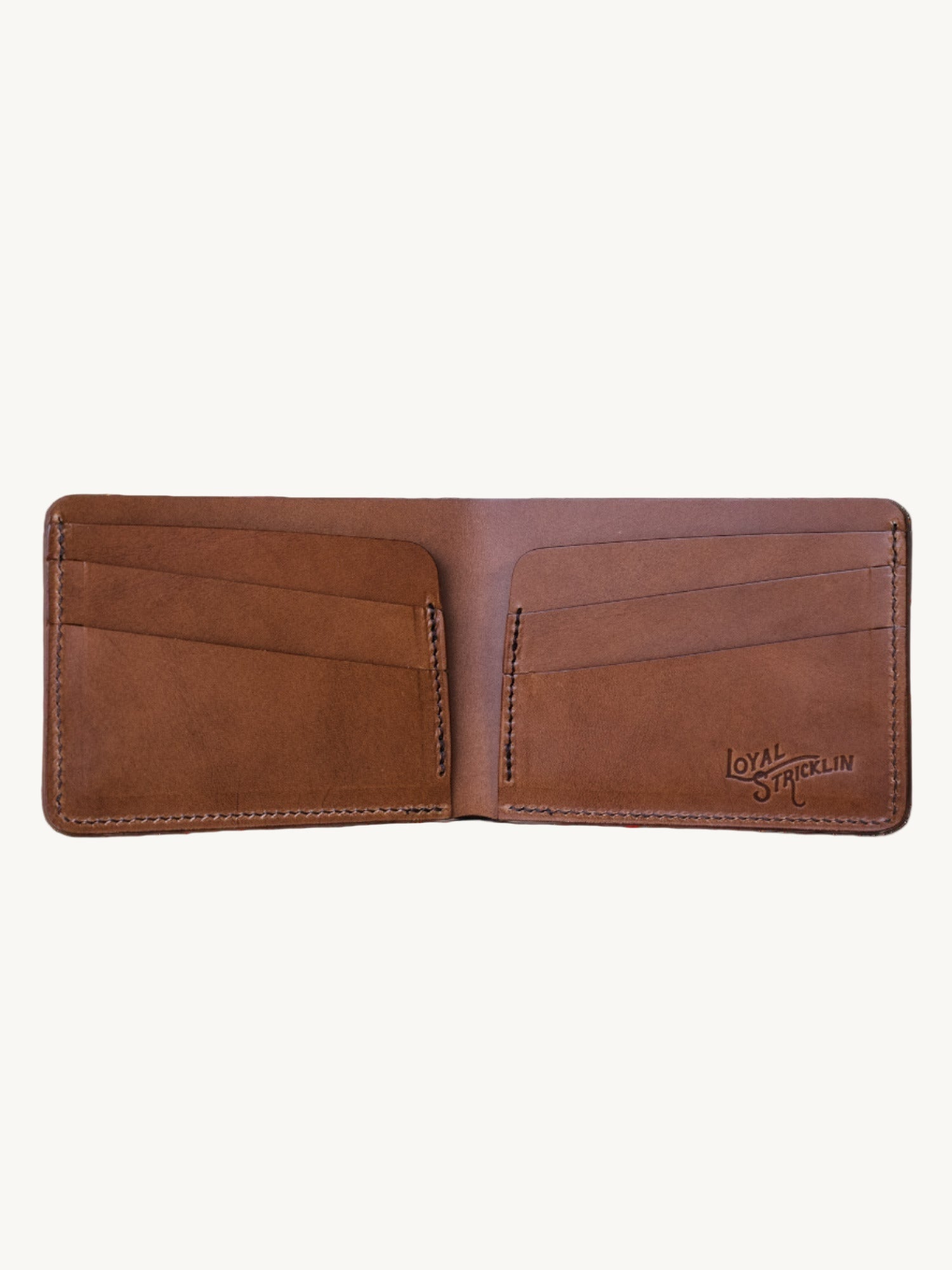 A bifold wallet made of brown leather, open to show multiple card pockets and the brand name 'Klein' embossed on the inside.