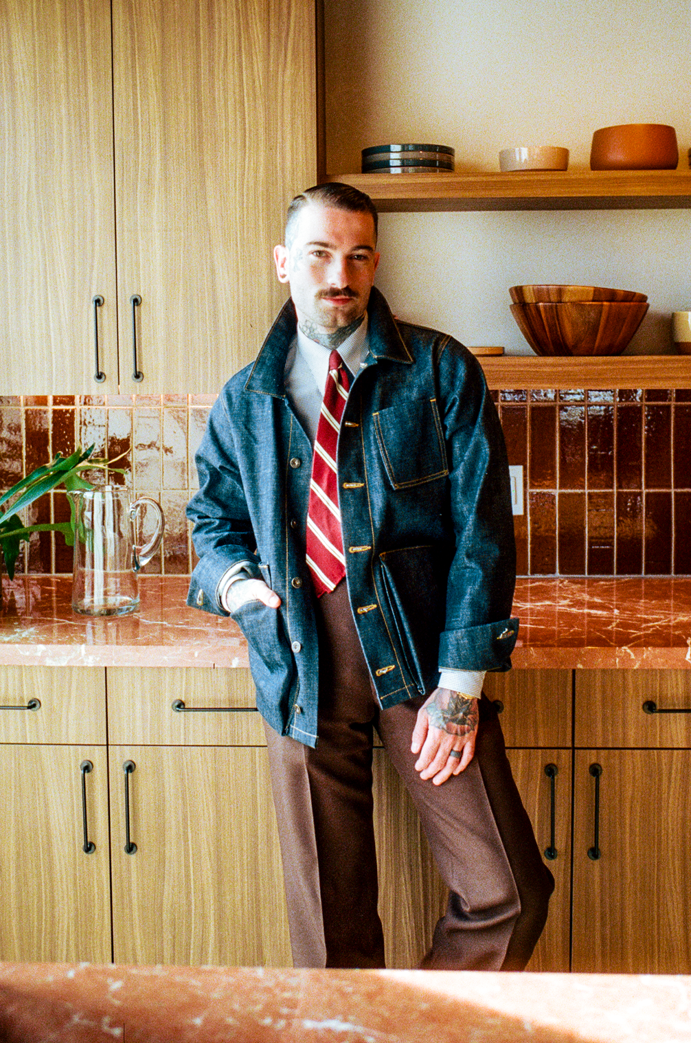 Man standing in a kitchen with wooden cabinets and countertops