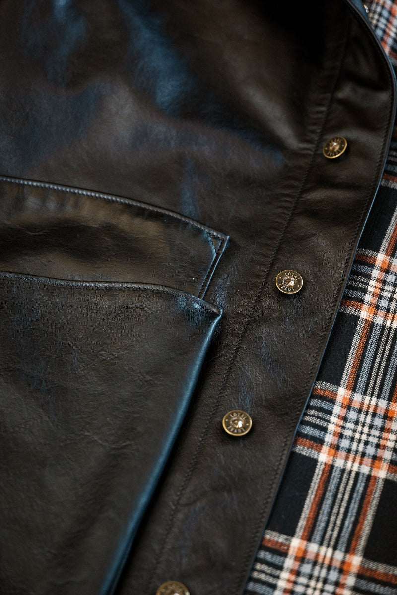 Close-up of a dark leather jacket with plaid lining