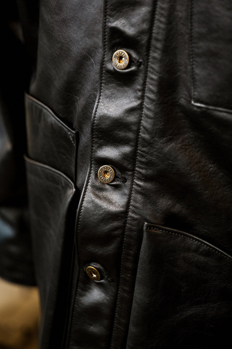 Close-up of a black leather jacket with gold buttons